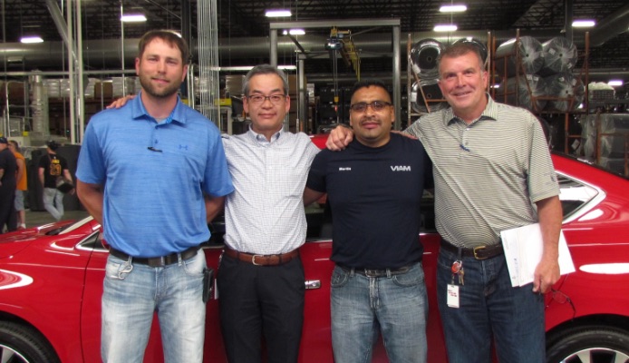 VIAM employees standing in front of a car